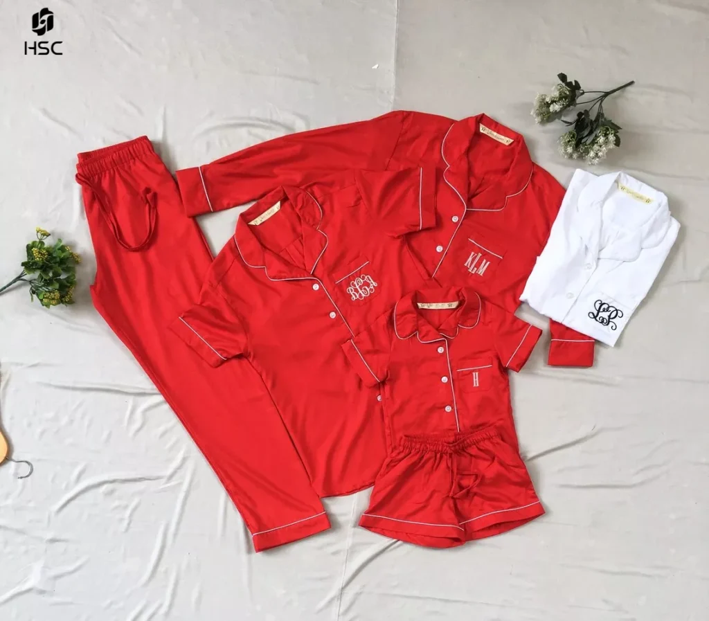 Red and white family Christmas pajama sets with monogram embroidery laid flat