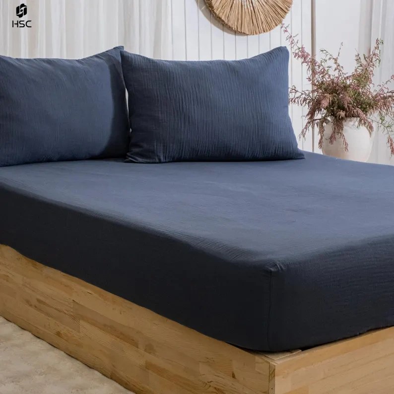 Navy cotton muslin bedding set with a fitted sheet and pillowcases