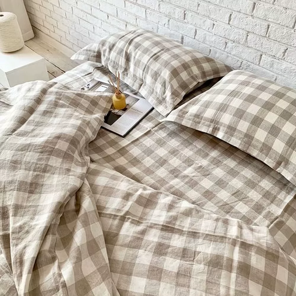 Beige and grey gingham check linen bedding set on a bed